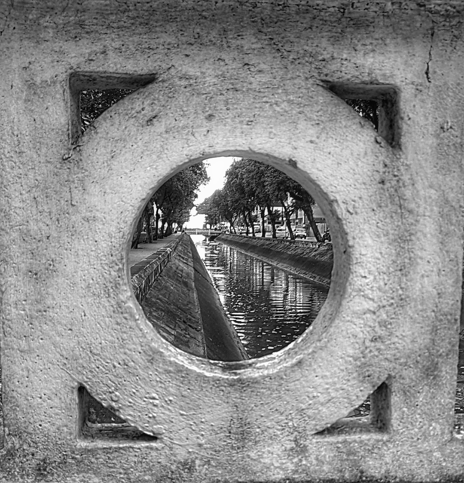 Detalhe da mureta de um canal de Santos, com o canal ao fundo