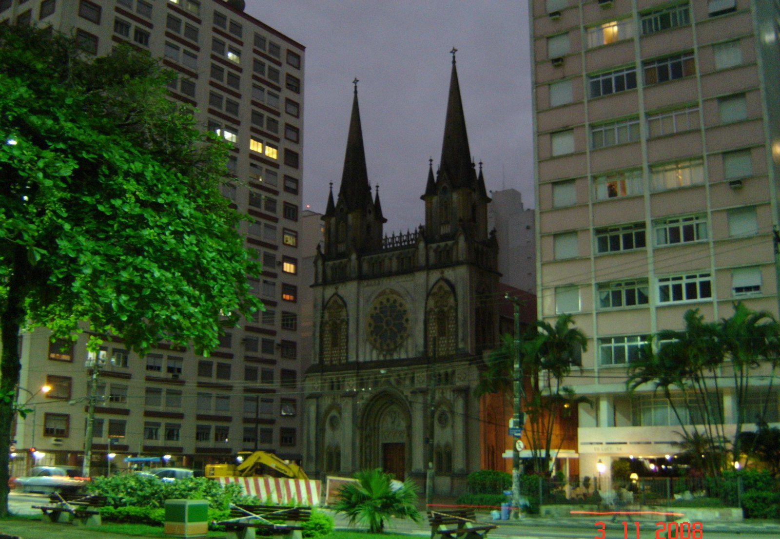 Sala de apartamento no Embaré, em Santos, com janela ampla e luz de fim de tarde Fachada da Basílica de Santo Antônio do Embaré, em Santos, vista da praça em frente